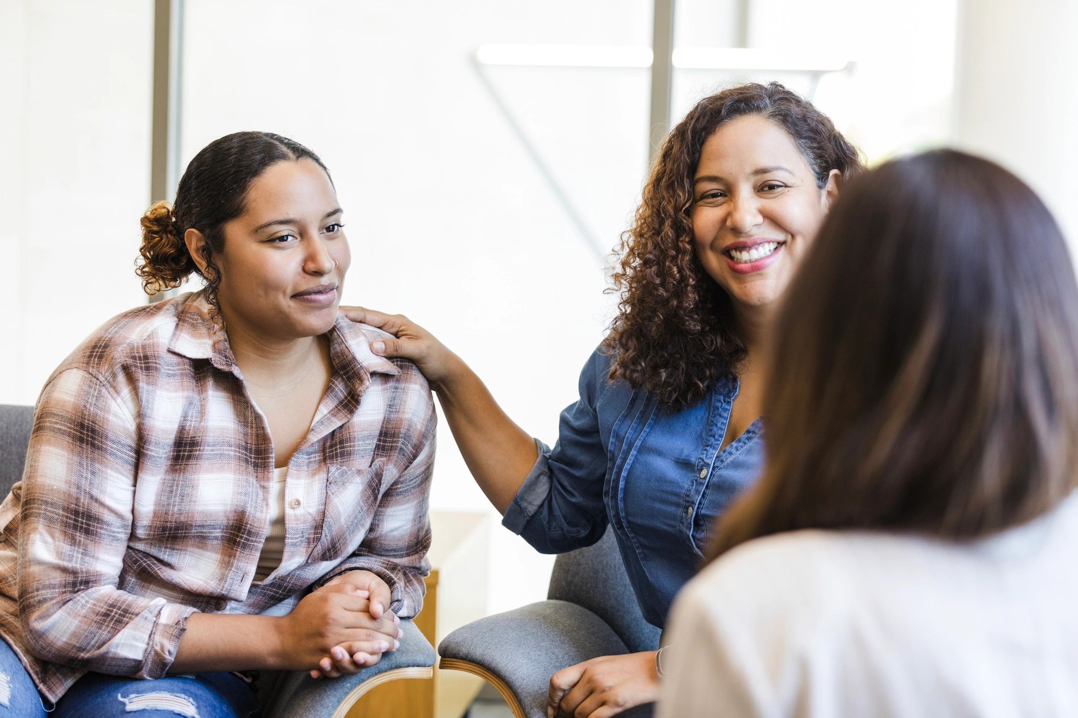 Mother smiles proudly while introducing her daughter to the intern coordinator