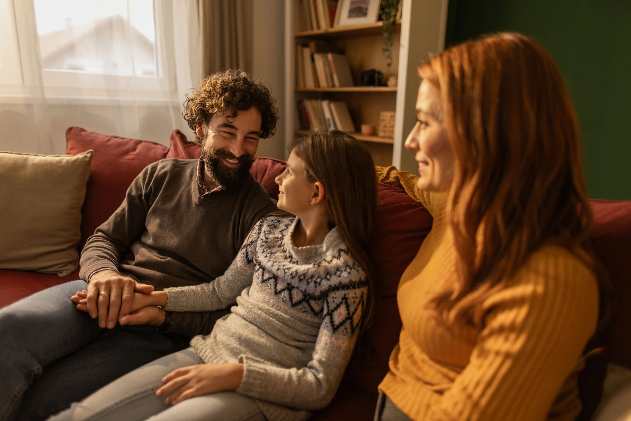 Family relaxing on sofa at home communicating