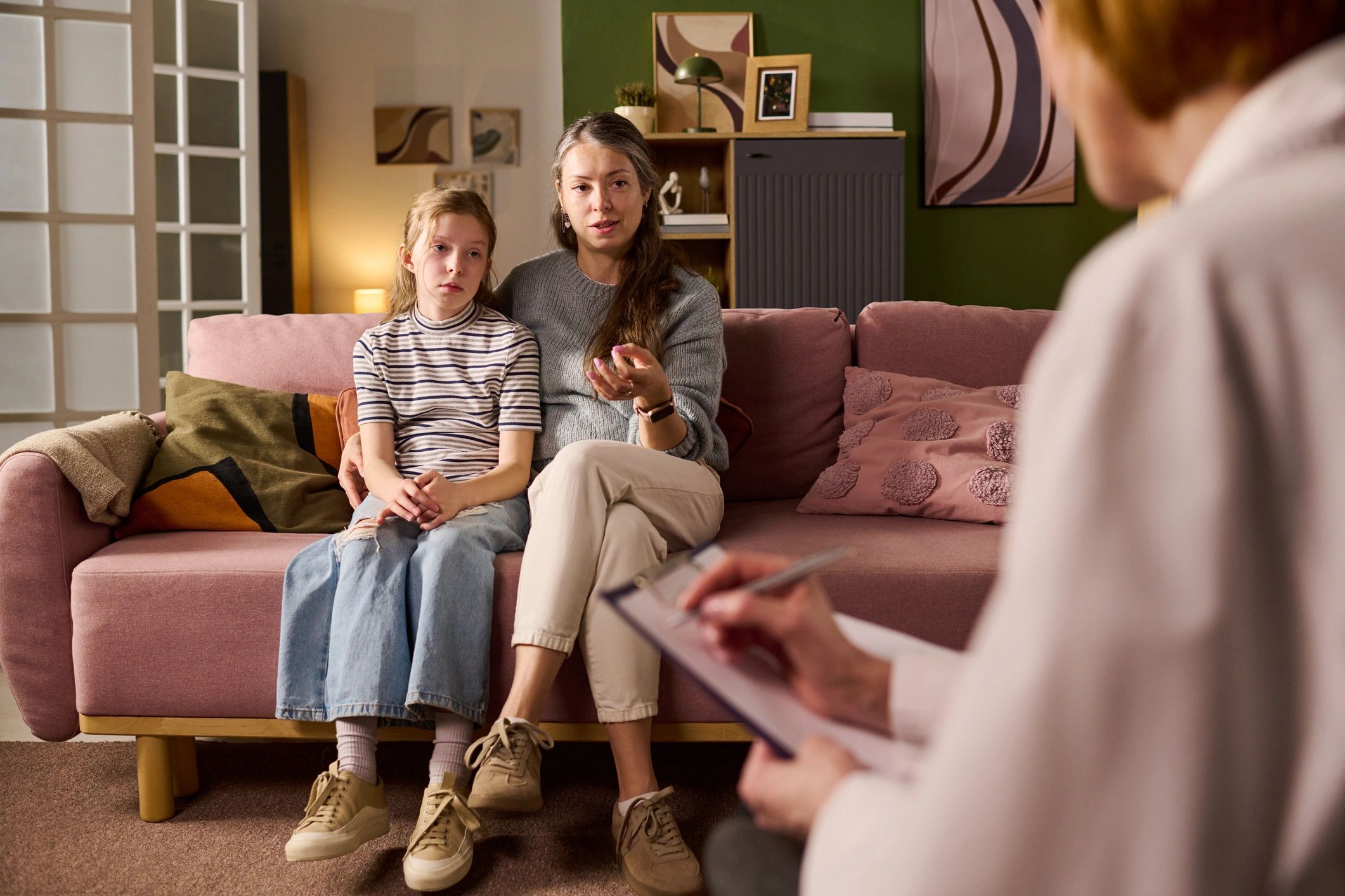 Mother and child meeting with a counselor in a supportive setting